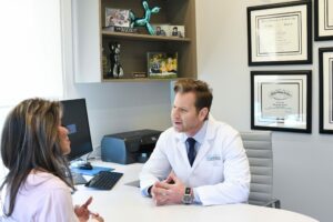 facial plastic surgeon consulting with a patient about surgical facelifts v. liquid facelifts in Charlotte