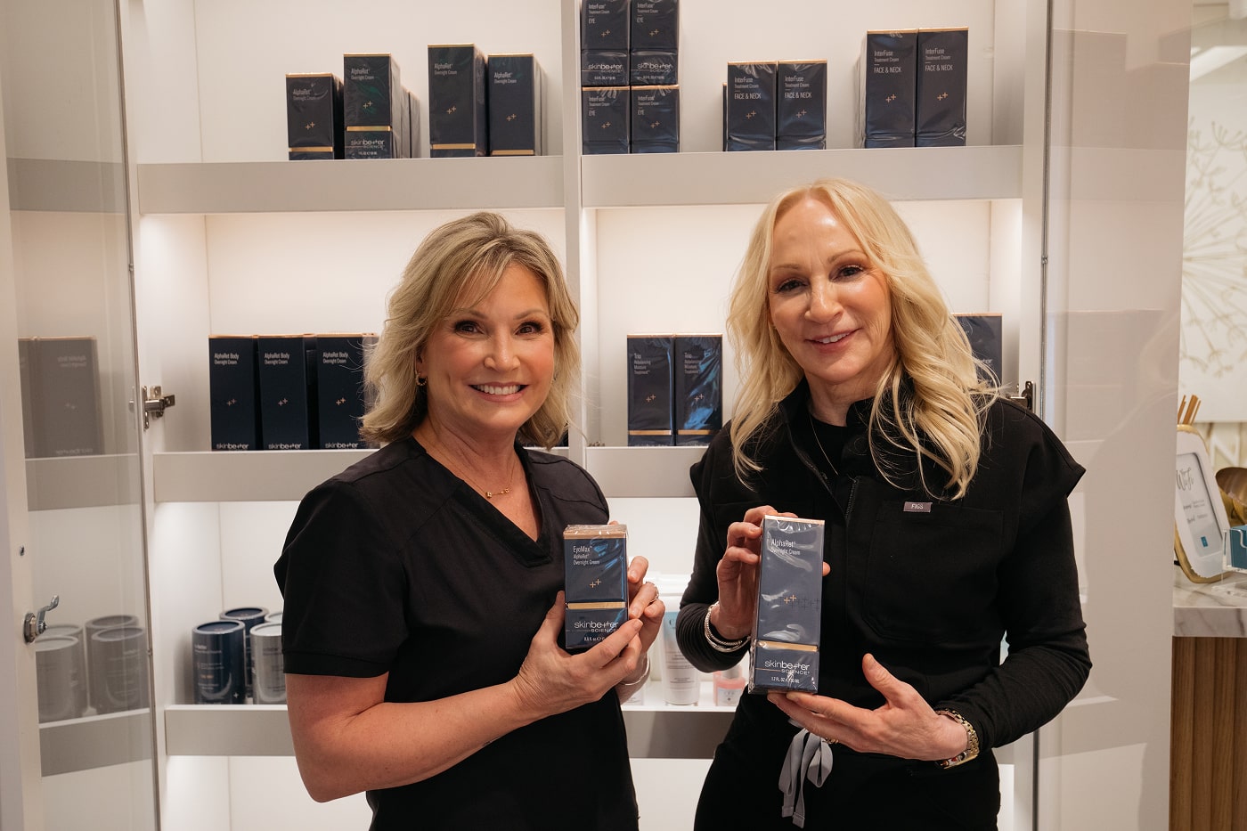 Aesthetician Kim Williams and a female patient showcasing skincare products at carolina facial plastics