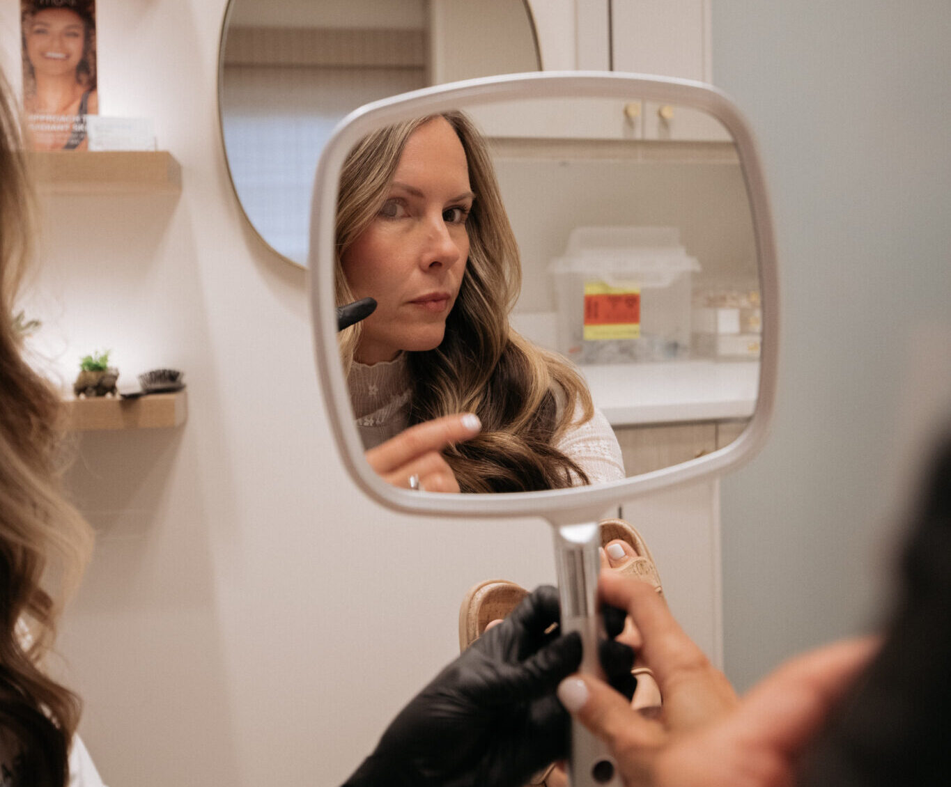woman looking in the mirror after custom facial